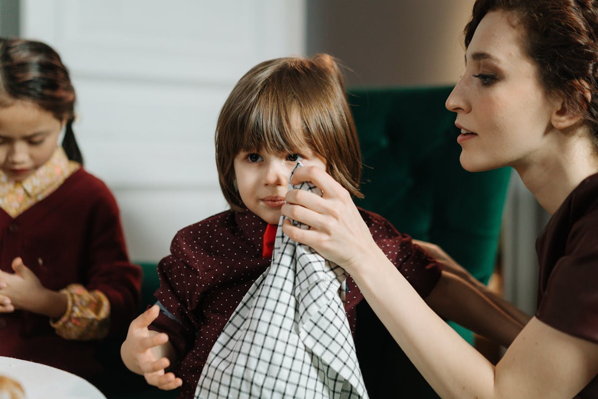 Caretaker assisting a young child during a meal at home.