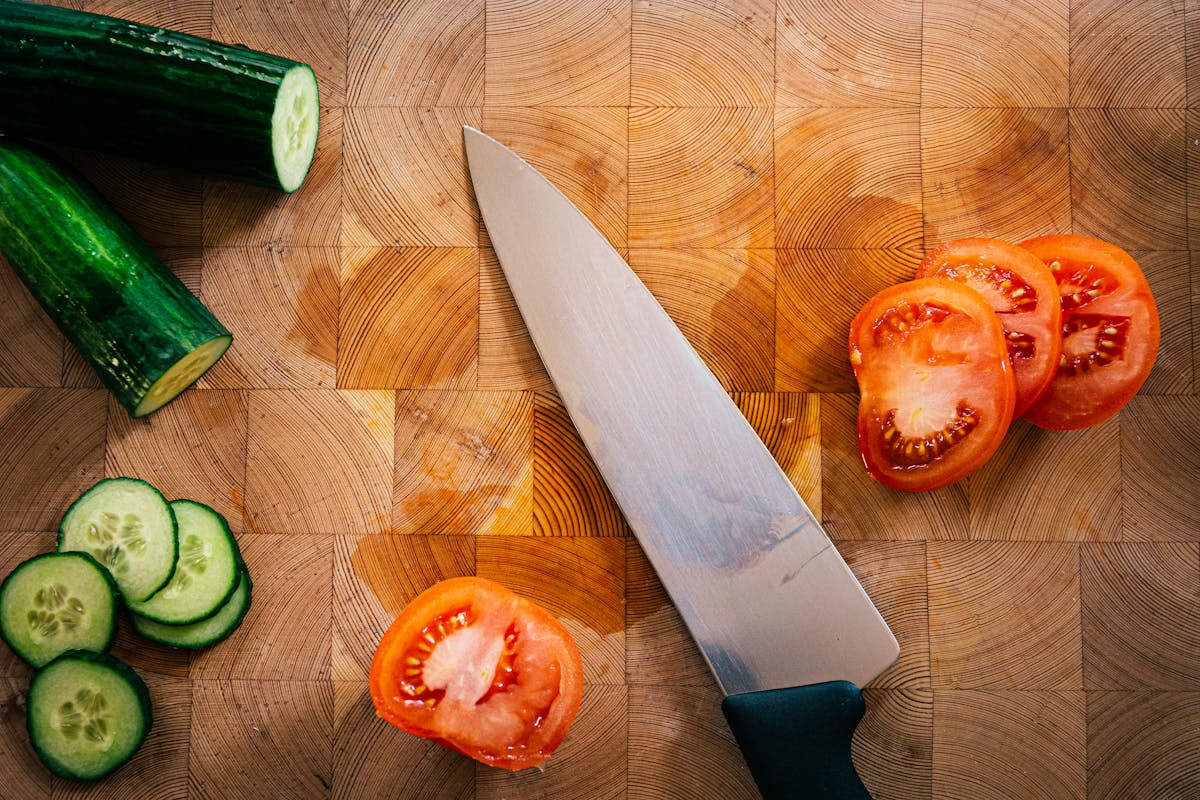Knife, cutting board, and prepped vegetables in a tidy kitchen