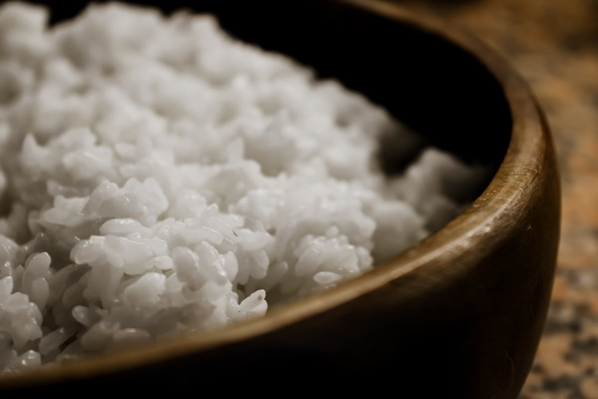 A pot of jasmine rice and a clear Chinese soup on a kitchen counter